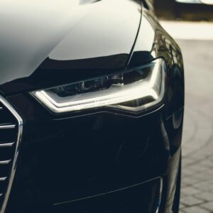 A sleek, modern luxury car showcasing its chrome detailing and LED headlights on a city street.
