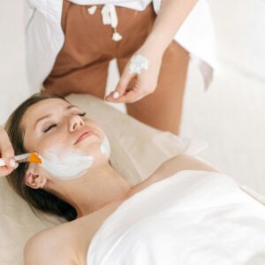 Woman receiving a rejuvenating facial treatment at a spa, promoting skin care and relaxation.